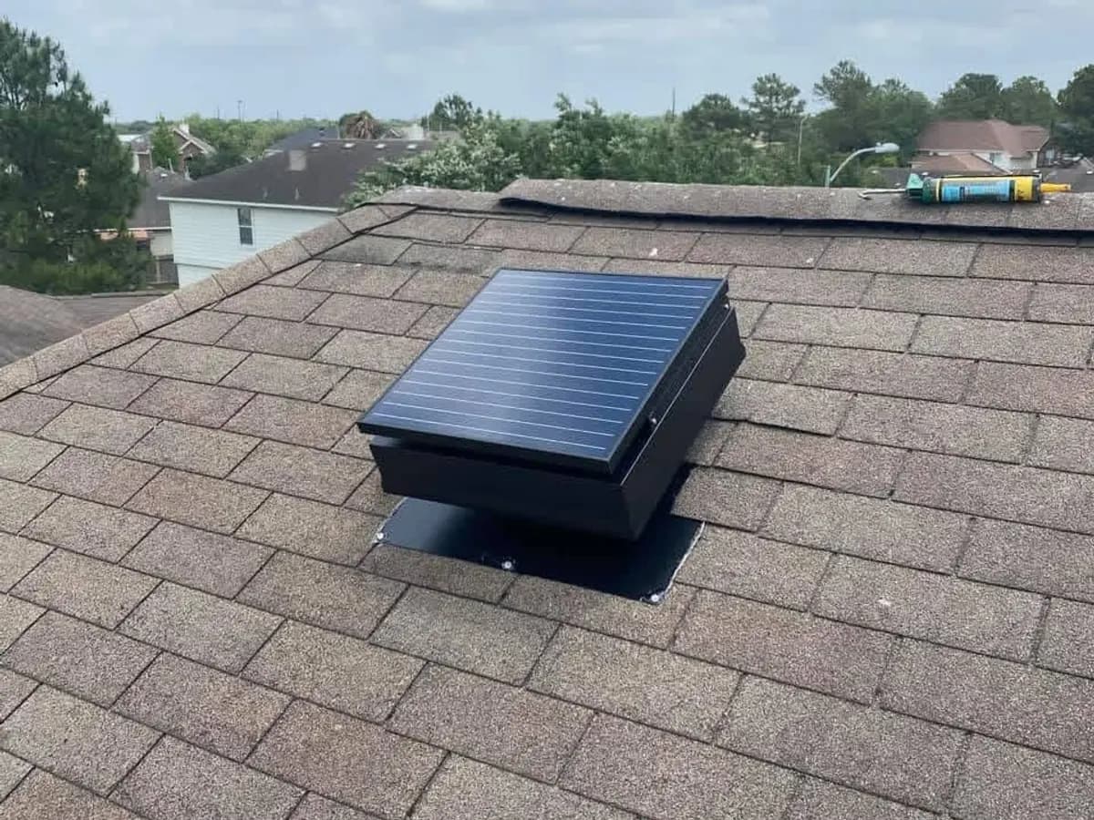 Solar attic fan close up on dark asphalt shingles