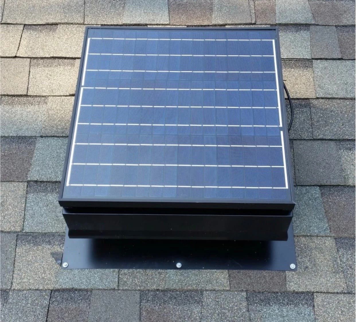 Solar attic fan on the back slope of a home